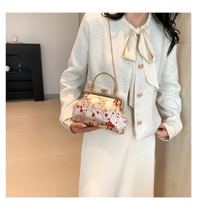 Detailed embroidery of red plum blossoms on a champagne satin small square bag