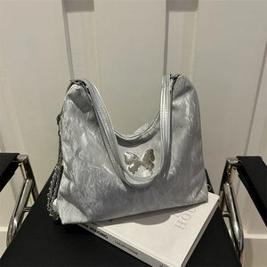 Metallic silver tote bag with ribbon butterfly detail and crinkled texture surface