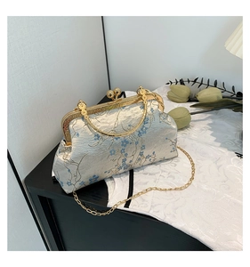 Detail of vintage floral brocade bag with gold metal frame and elegant chain strap