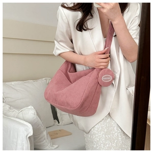 Pink corduroy hobo bag with a matching round mini coin purse shown in a mirror selfie view