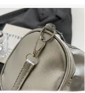 Detailed close-up of metallic silver pillow bag featuring ripple texture and glossy hardware