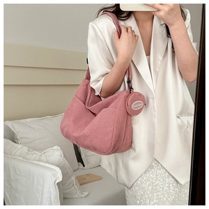 Pink corduroy hobo bag detail with vertical texture and a mini coin purse pendant