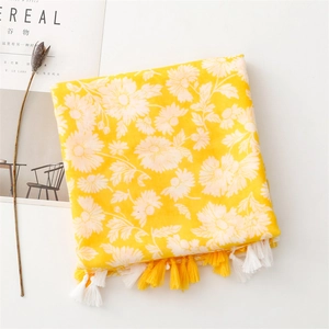 Detail of yellow daisy print cotton linen scarf with soft fringe tassels on the edge