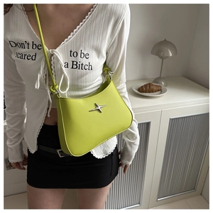 Detail of lime green faux leather shoulder bag with silver star and knot strap design