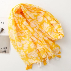 Detail of yellow cotton-linen scarf featuring white daisy floral prints and fringe tassels