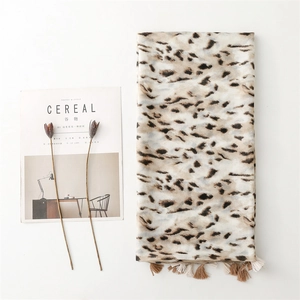 Soft cotton-linen leopard print scarf for women with tassels on a white background