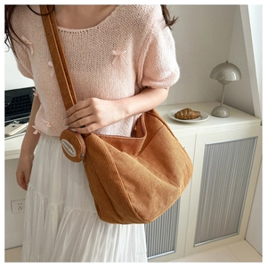Detailed texture of brown corduroy tote bag with small matching round pouch and zipper
