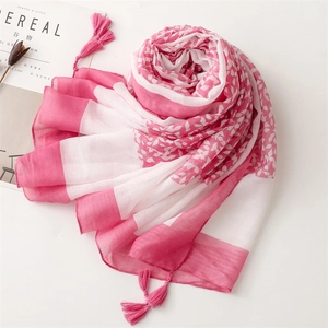 Close-up of pink leaf pattern scarf with delicate handmade fringes on cotton-linen fabric