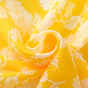 Macro view of yellow floral cotton-linen fabric with herringbone weave and flower patterns
