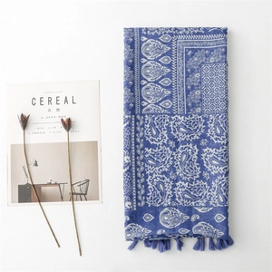 Close-up of blue linen scarf with white paisley pattern and decorative tassels on side