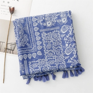Detail of blue paisley pattern scarf with tassels and elegant cotton-linen texture