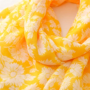 Detail showing bright yellow linen-feel scarf with elegant white floral print patterns