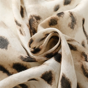 Macro detail of soft leopard print scarf showing the breathable weave texture and fringe