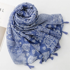 Detail of blue and white paisley pattern scarf with soft tassels and cotton-linen texture
