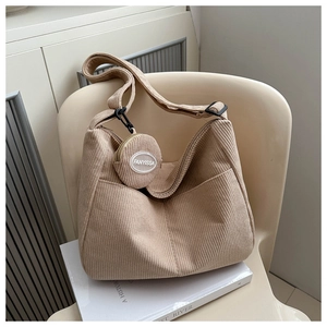Detail of beige corduroy shoulder bag with removable round coin purse and black hardware
