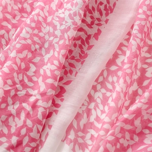 Macro detail of breathable cotton-linen feel scarf with pink leaf patterns and soft drape