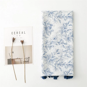 Détail d'une écharpe en lin à imprimé lys bleu avec franges élégantes sur fond blanc