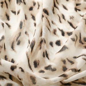 Macro detail of soft leopard print fabric with natural folds and silky texture