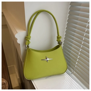 Detail of avocado green crossbody bag with knotted strap and silver star ornament