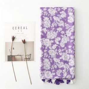 Detailed view of purple floral cotton scarf with white daisy patterns and fringe edges