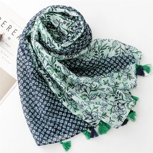 Linen feel floral scarf with green and blue patterns and tassel edges on white background