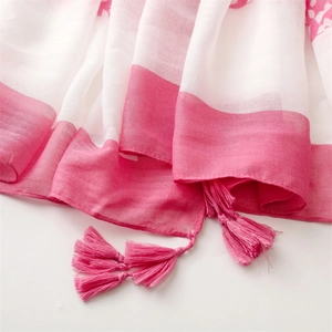 Close-up of pink and white striped cotton-linen scarf featuring decorative tassel details