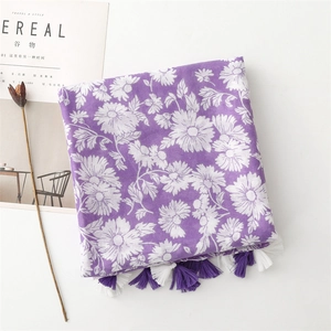Close-up of purple floral linen scarf with white daisy prints and delicate fringe edges