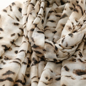 Detailed close-up of leopard print scarf fabric showing soft texture and drapes