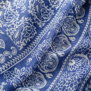 Detailed close-up of dark blue paisley and floral print fabric with a soft cotton texture