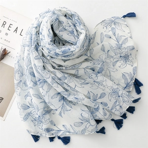 Vue détaillée d'une écharpe en coton-lin à motif floral avec des glands élégants