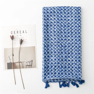 Navy blue cotton linen scarf with fish scale pattern and tassels on minimalist white background