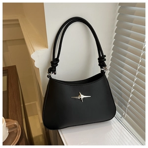 Close-up of knot-detail shoulder strap and silver star ornament on black crossbody bag