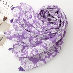 Detail of purple scarf with white daisy print, fringe tassels and artistic magazine props