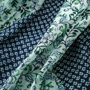 Close-up of floral print cotton linen fabric with navy blue and mint green contrast