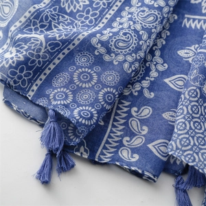 Detail of navy blue cotton linen scarf featuring white Paisley prints and tassel trim