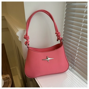 Detail of pink underarm bag featuring silver star buckle and stylish knotted strap design