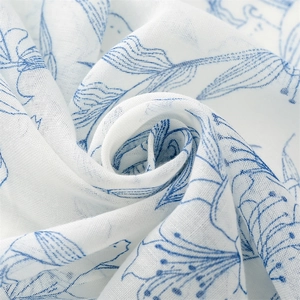 Détail de l'écharpe en coton et lin avec motif floral bleu et texture tissée