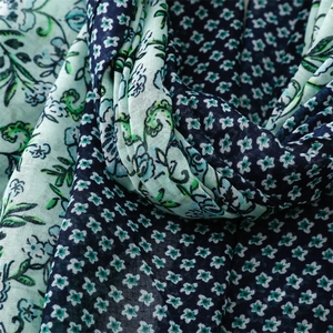 Detailed macro view of mint green and navy floral print fabric with soft pleats