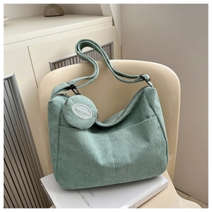 Detail of mint green corduroy shoulder bag texture with small round hanging coin purse