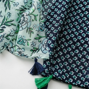 Detailed view of floral print scarf fabric with cotton-linen feel and delicate tassels