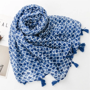 Close-up of blue and white geometric fish scale pattern scarf with tassel edge