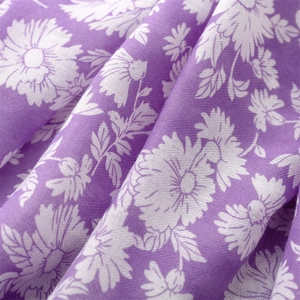 Detail of soft purple cotton linen scarf showing delicate white daisy floral patterns