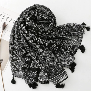 Detail of bohemian black and white paisley print scarf with tassels on white background