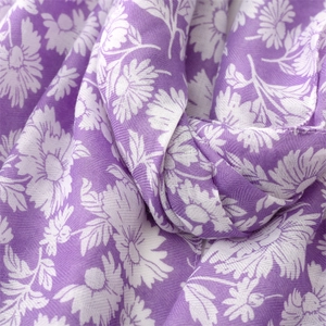 Macro detail of purple herringbone scarf fabric with white daisy floral patterns