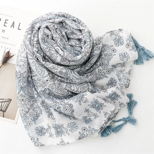 Detailed shot of the blue floral pattern and dark tassels on the cotton linen scarf