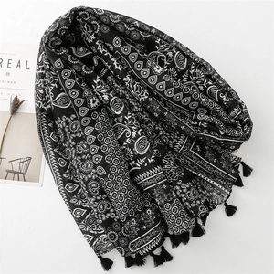 Detail of black and white paisley floral scarf featuring delicate fringe tassels