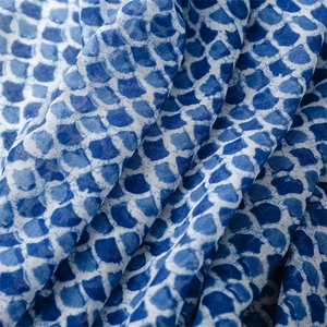 Macro shot of blue fish scale pattern on linen-touch scarf fabric with elegant texture