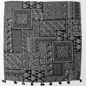 Detail of vintage paisley pattern on black cotton scarf with delicate tassel fringe