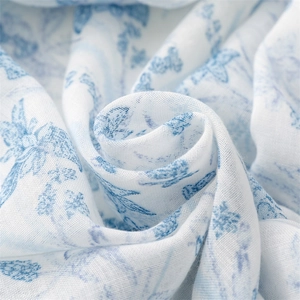 Macro detail of breathable light blue floral scarf fabric with soft fringe texture