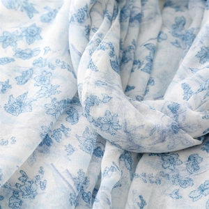 Macro view of light blue floral cotton linen scarf showing breathable weave texture